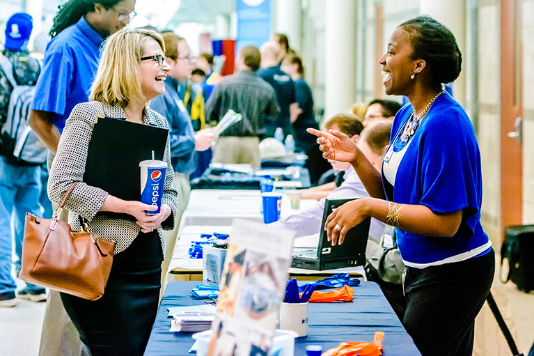 Two women talking at a past job fair event
