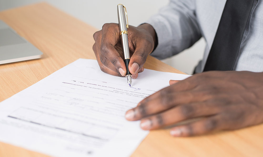 stock photo - man writing on a paper form