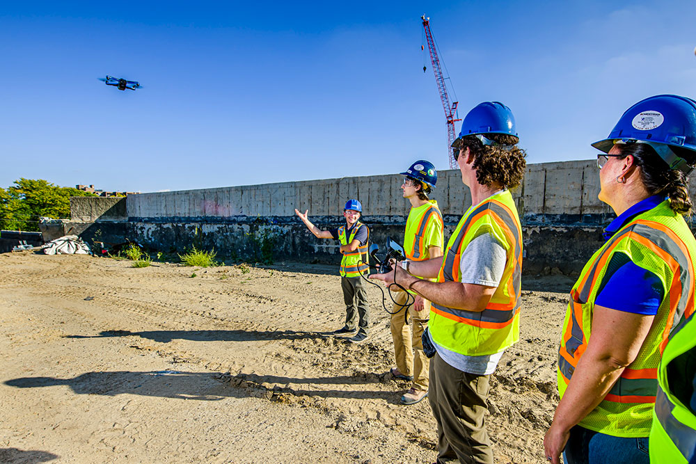 students flying a drone at an outdoor practice setting
