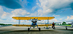 A biplane sits on the runway of the Mason Jewett Airport on a cloudy day