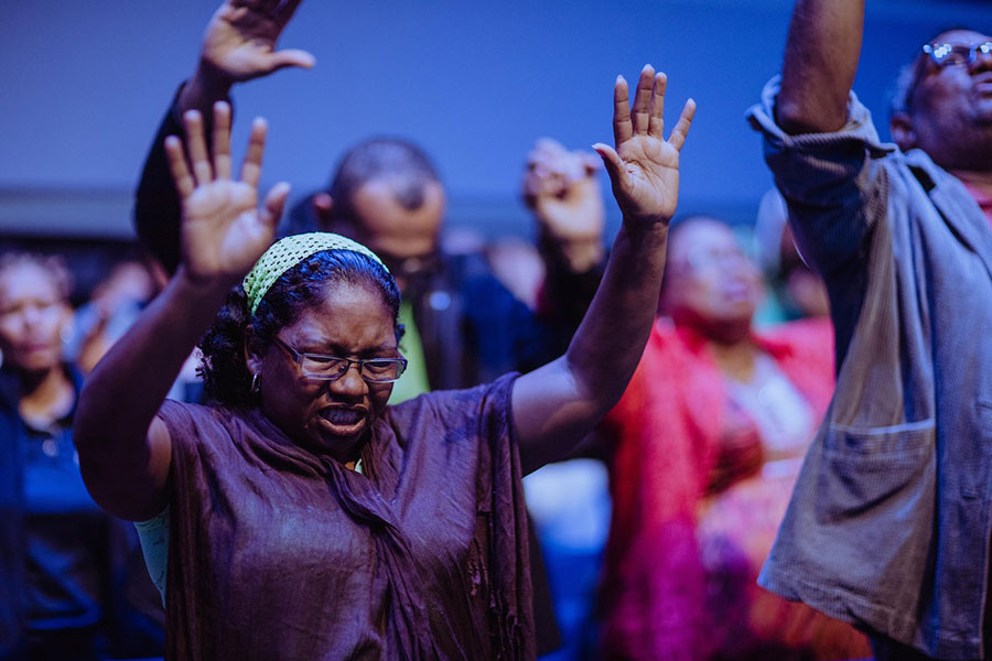 people praying with their hands in the air