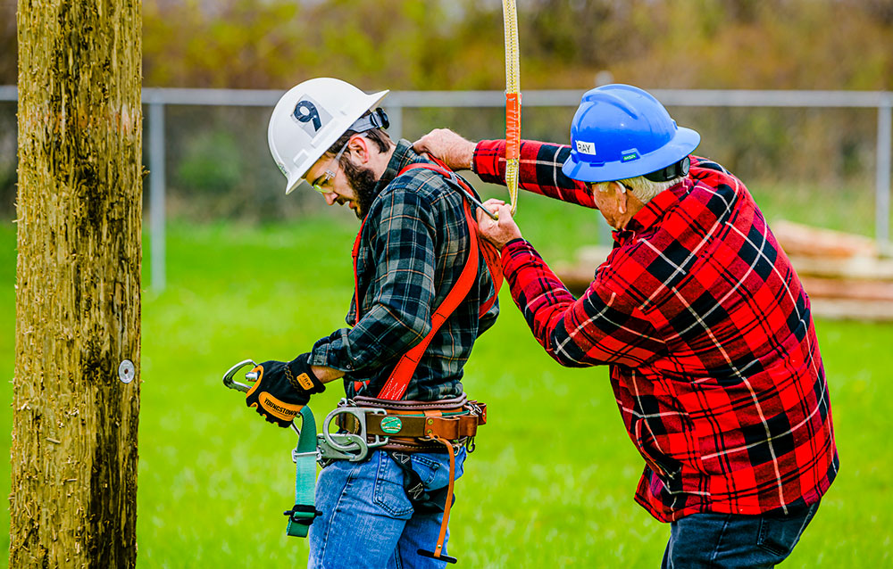 student being harnessed by instructor at west campus