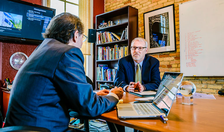 two men in suits talking business at local small business