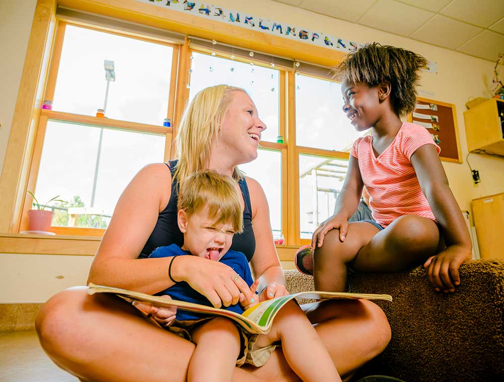 Women reading a book to kids