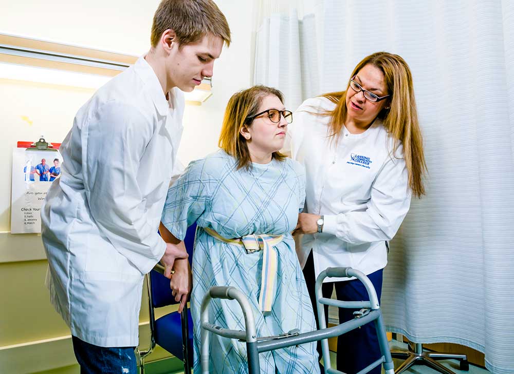 Nurses helping a patient walk with a walker