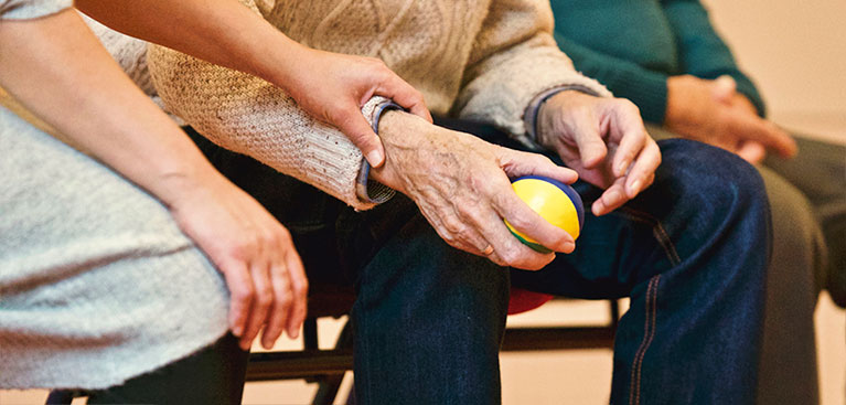 nurse holding older man's hand