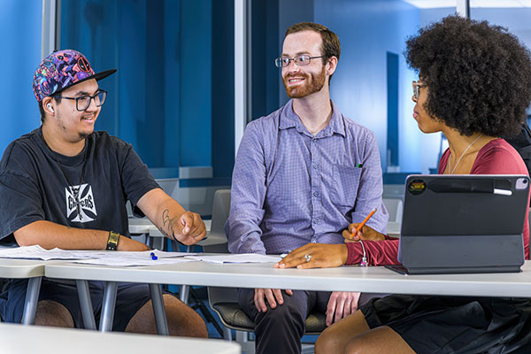 two people smiling while working at a desk