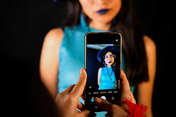 person taking a portrait of another person with their phone