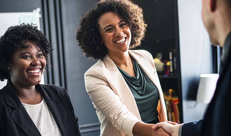 people smiling and shaking hands while meeting others