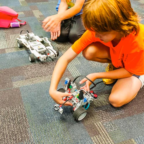 Two kids playing with robots.