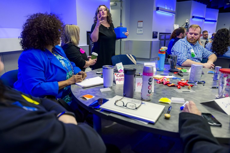 Staff work around a table on a common problem at the Collaborative Growth Institute event 