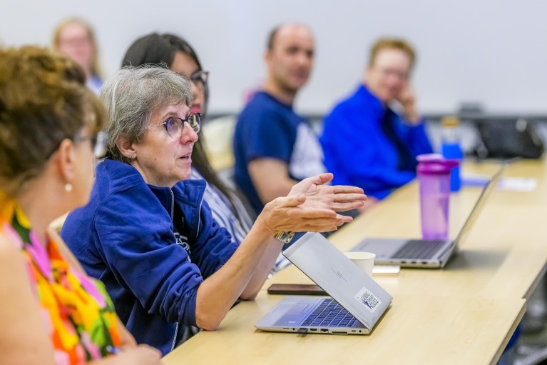 A woman makes a point as other staff look on at Discovery Days