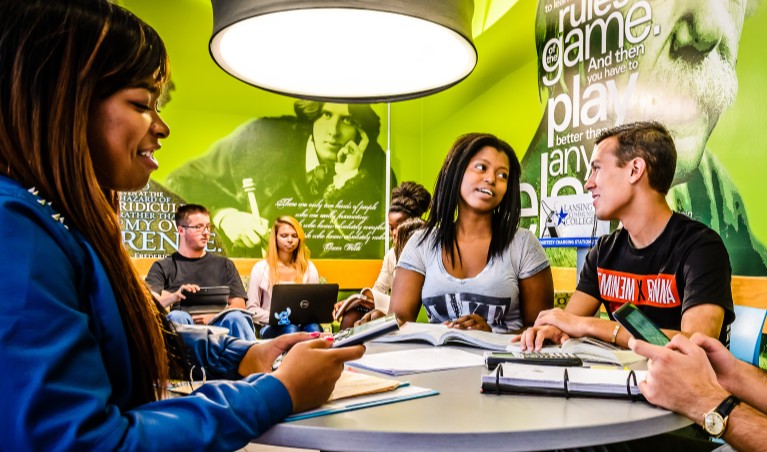 a group of students talking while sitting down at a table