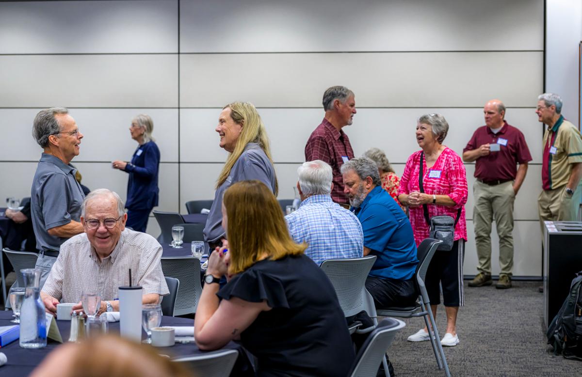 A group of people around a table talking.