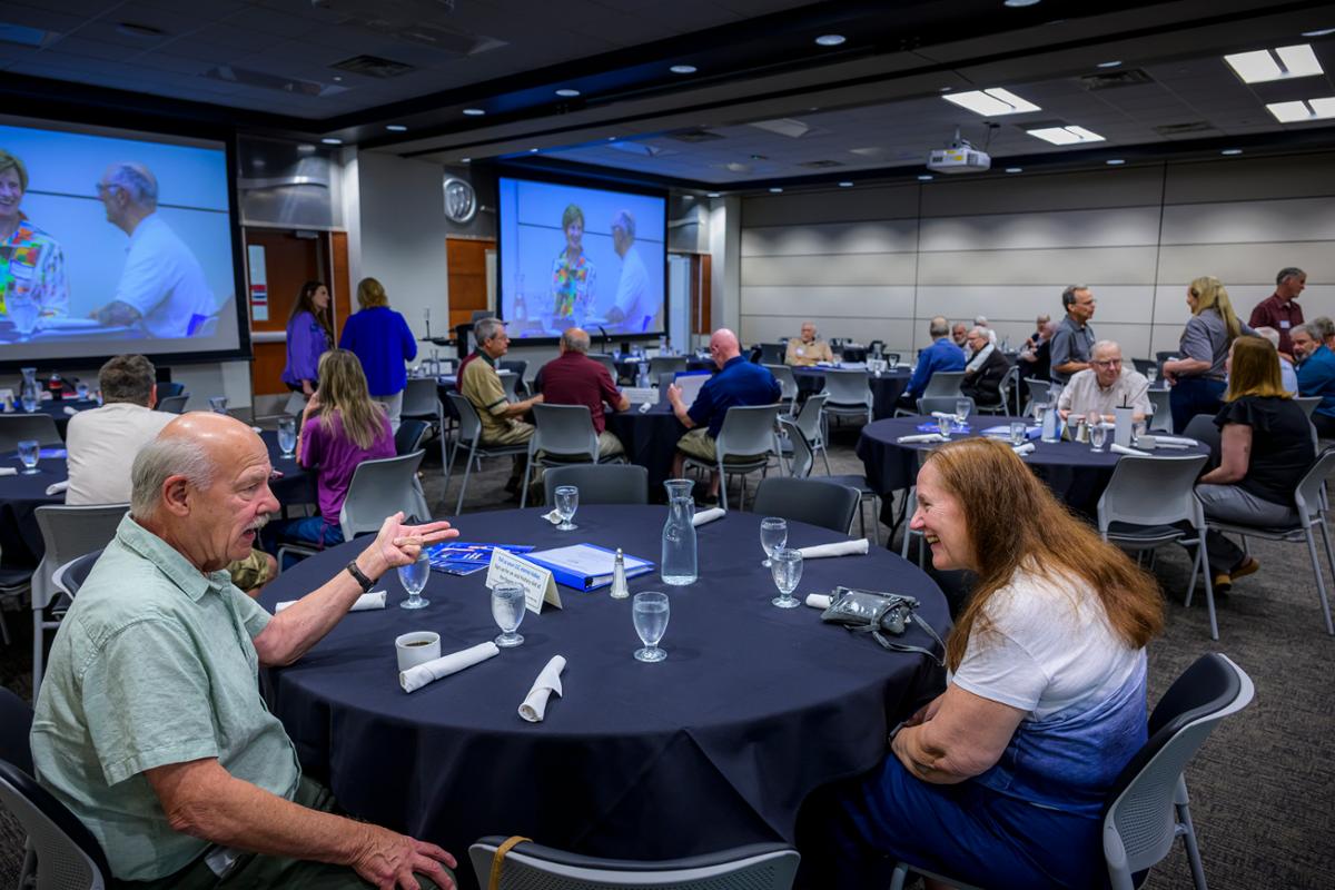 A group of people around a table talking.