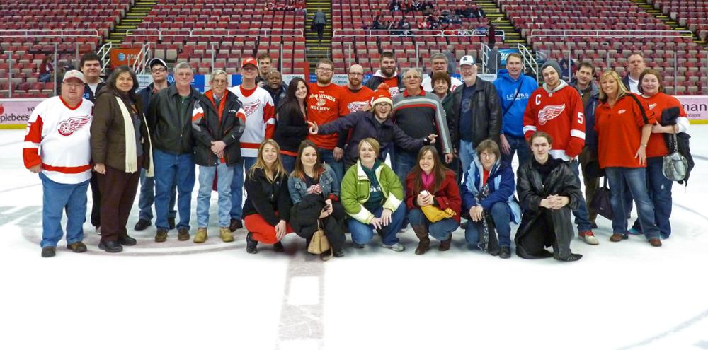 Anita and a group of people at center ice at a red wings game