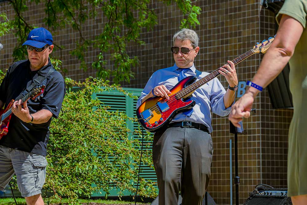dr. robinson playing his bass in a band performance