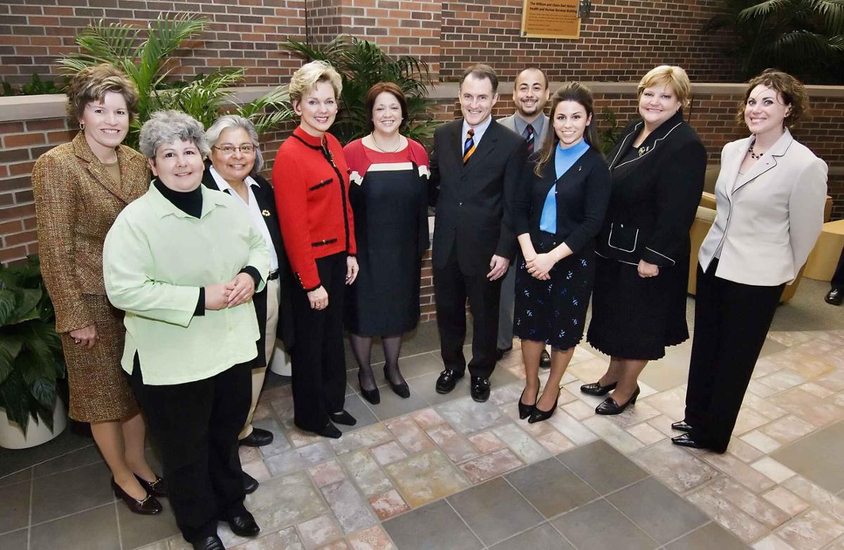 A group of people stands together in the atrium of the Health and Human Services building.