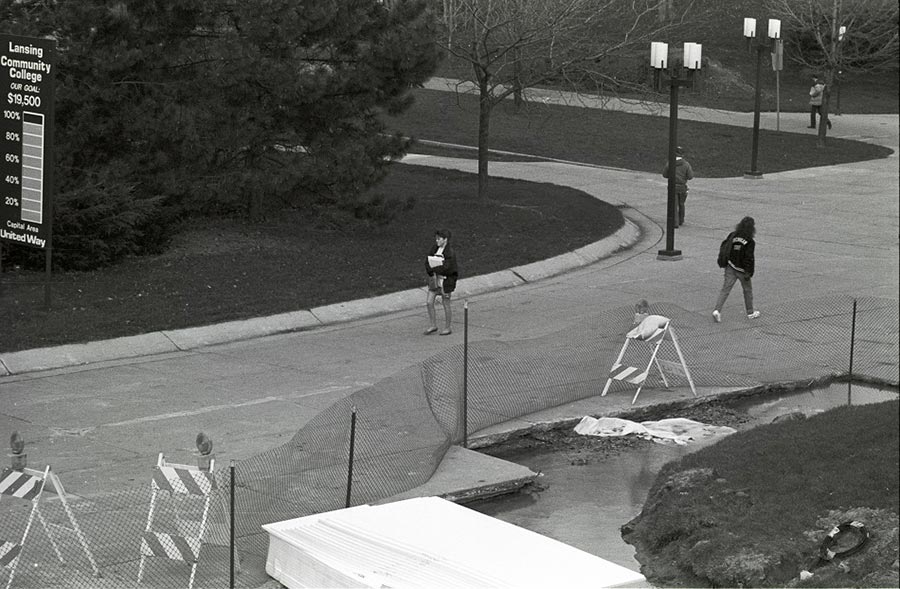 Students walk around Gannon Building construction that is spilling onto the Washington Mall - ca. 1980s