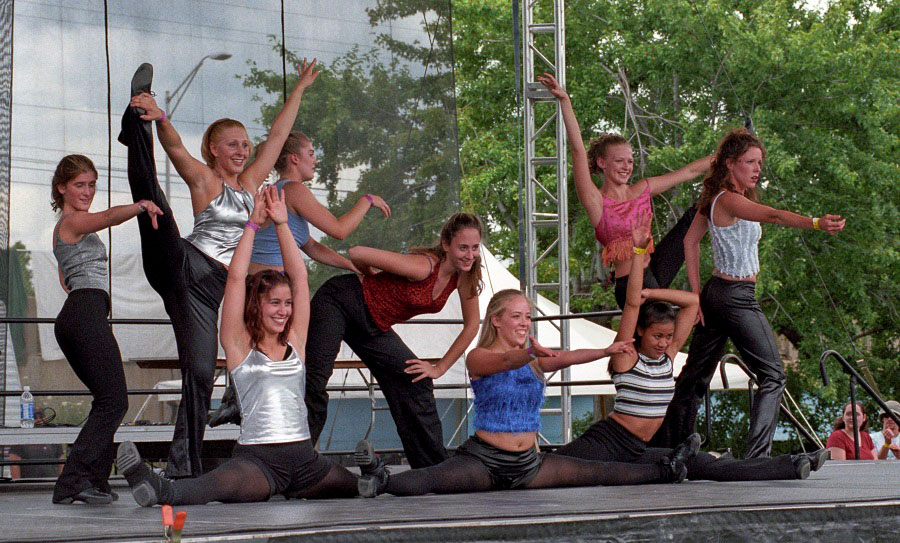 Dancers from the Art of Combat demonstration strike a pose on a stage at Adado Riverfront Park - ca. 2000s