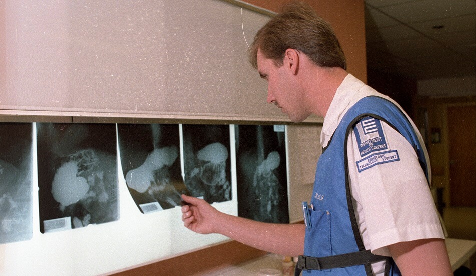 A Radiologic Technology Student from the LCC Department of Health Careers views X-Ray film against a light board - May 1988