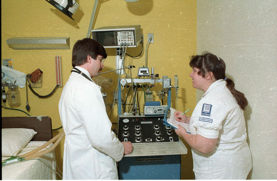 A Respiratory Therapy student from the LCC Department of Health Careers takes down information while with a doctor - ca. 1980s