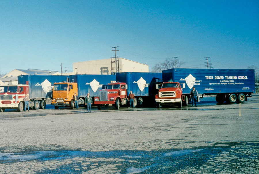 Students and staff stand by the trucks used in LCC's Truck Driver Training School - ca. 1970s-1980s