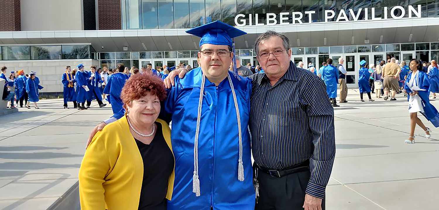 Hansel Valdes standing with his parents after graduation
