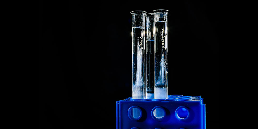 Three test tubes filled with a transparent liquid sit in a rack