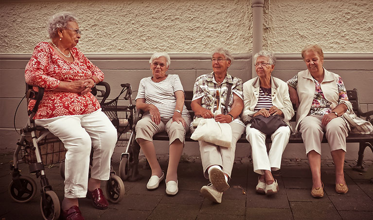 Senior women on a bench happily chat