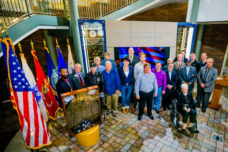 veterans standing in front of memorial piece