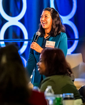 women holding a microphone and speaking to an audience