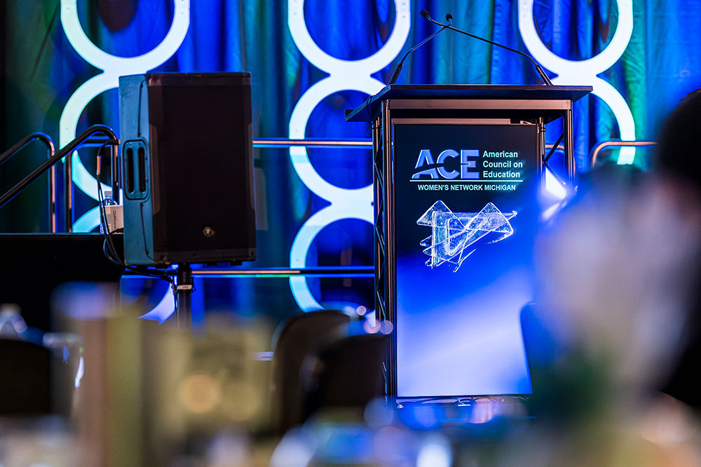ace women's network michigan logo on a podium on stage
